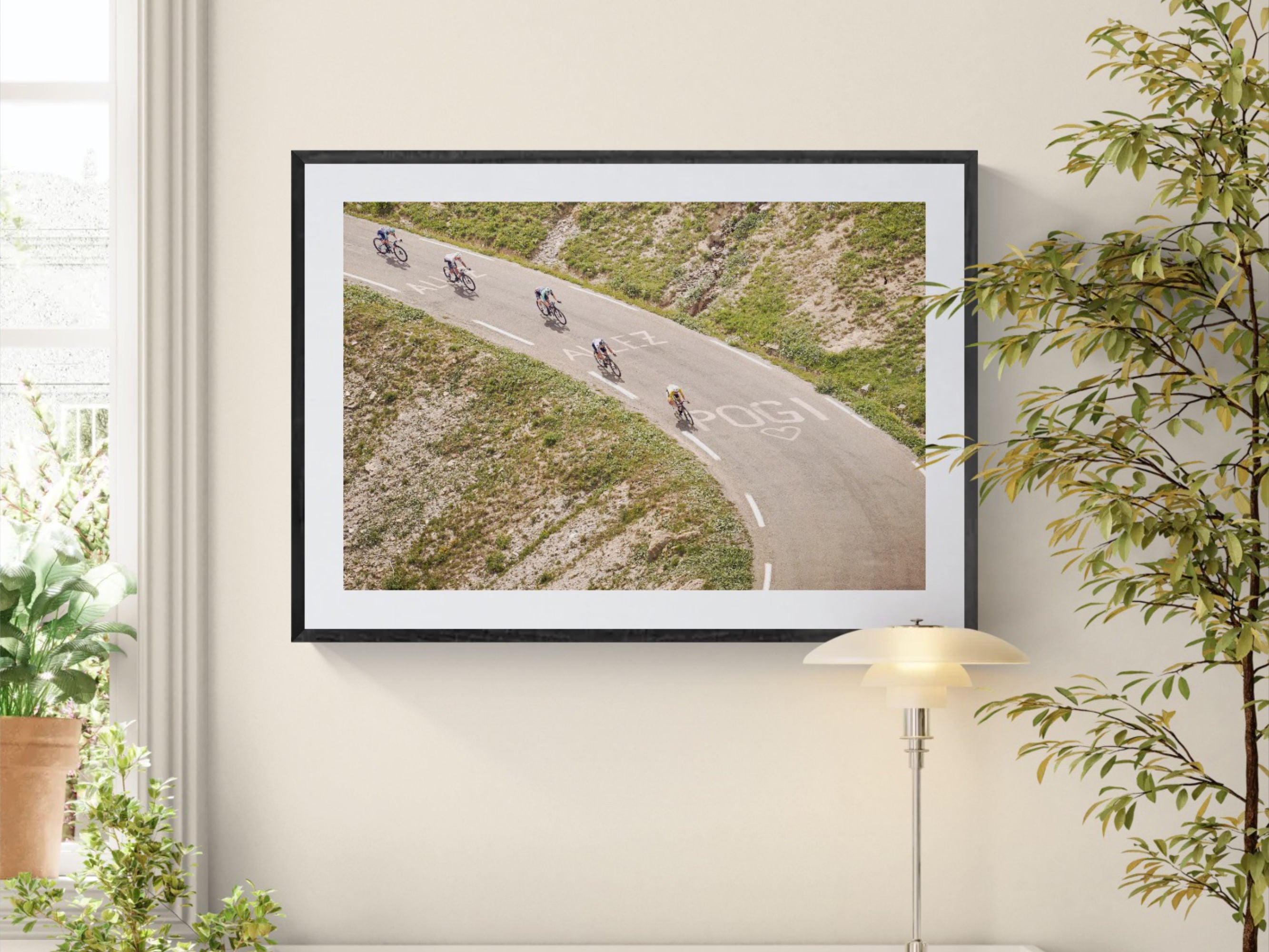 Tour de France Col du Galibier print framed on wall near window with lamp