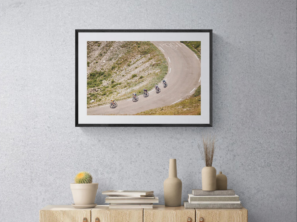 Tour de France Col du Galibier print framed on wall near window with lamp